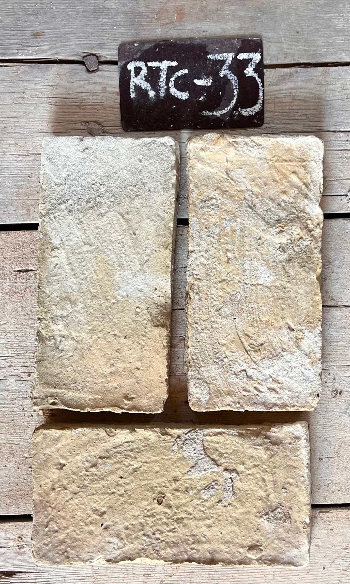 Tres piezas de barro cocido recuperado en beige dorado con estrías horizontales visibles, formato 24x12 cm