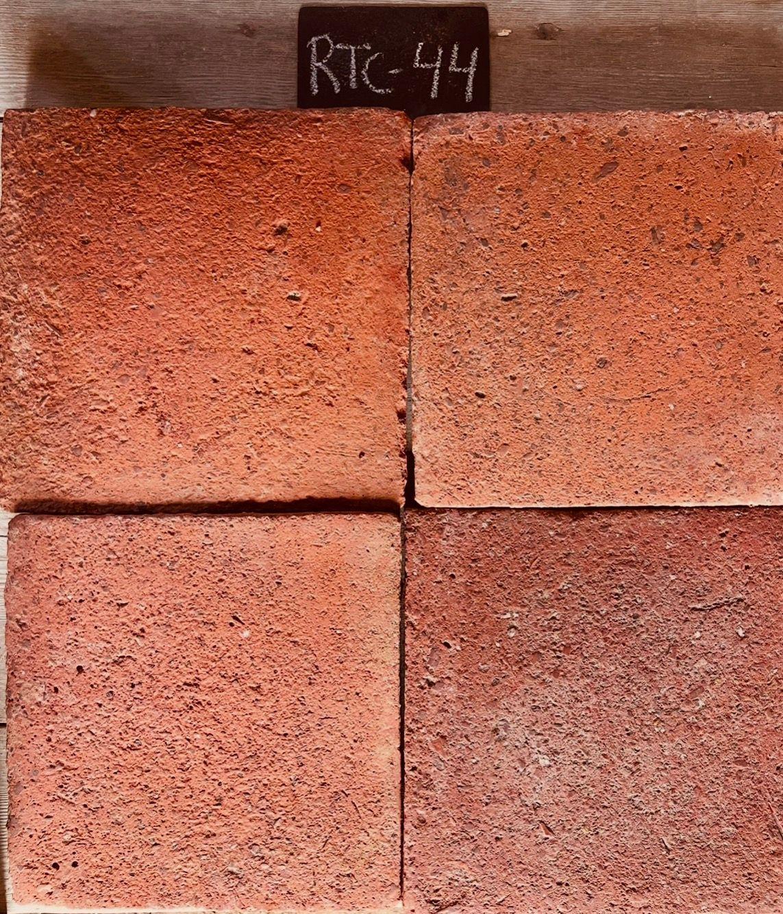 Cuatro piezas de barro cocido recuperado en terracota salmón uniforme, formato 27x27 cm