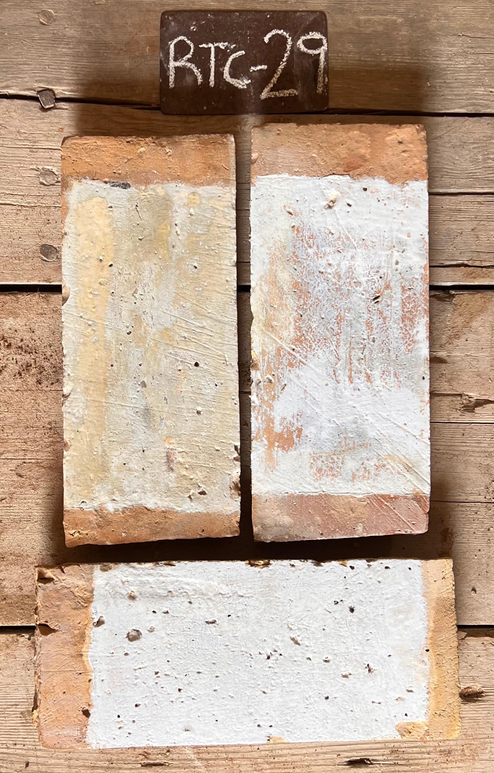 Dos piezas de barro cocido recuperado, una en crema claro y otra con matiz terracota, formato 14x31 cm
