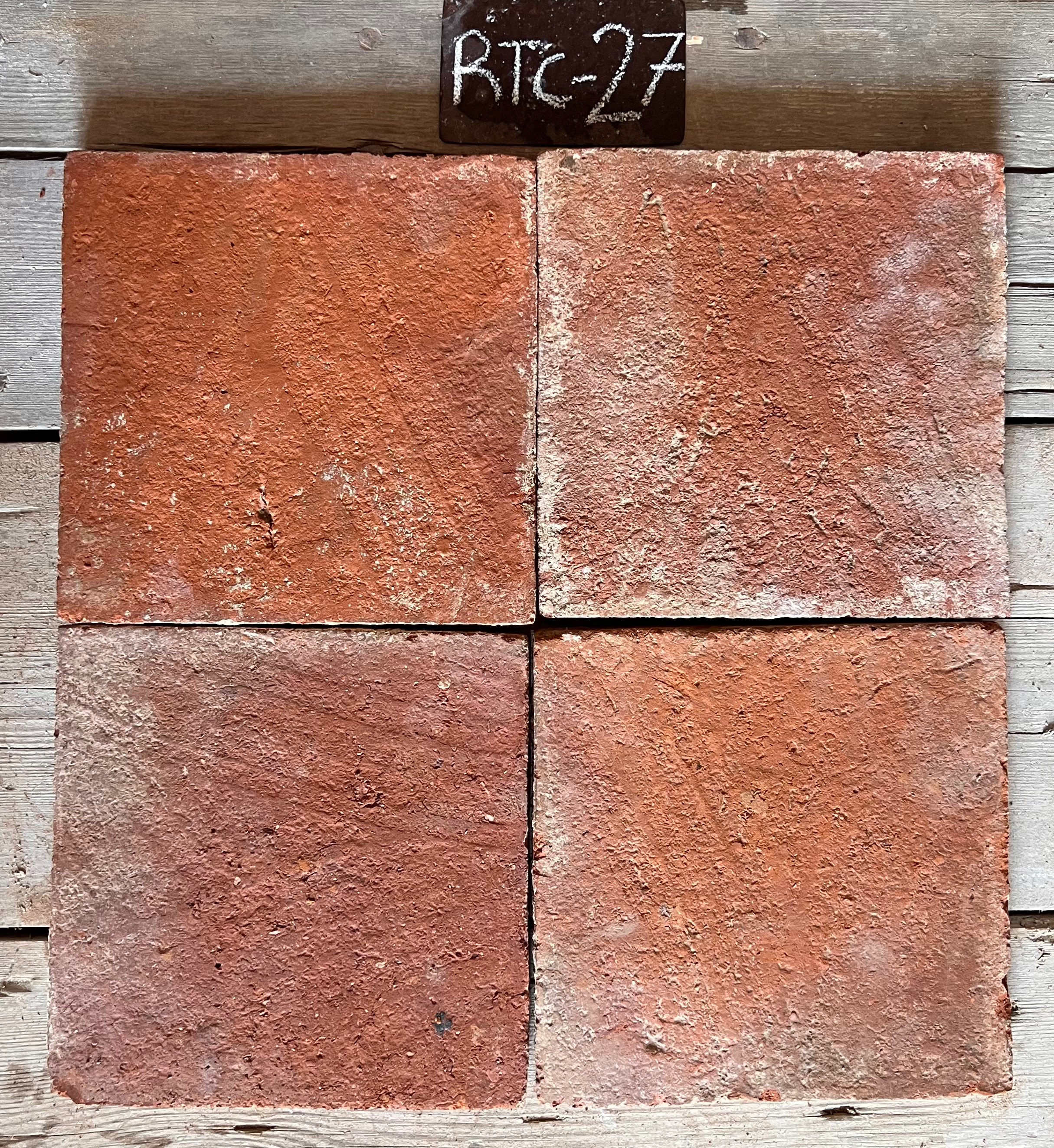 Cuatro piezas de barro cocido recuperado en terracota salmón uniforme, formato 25x25 cm