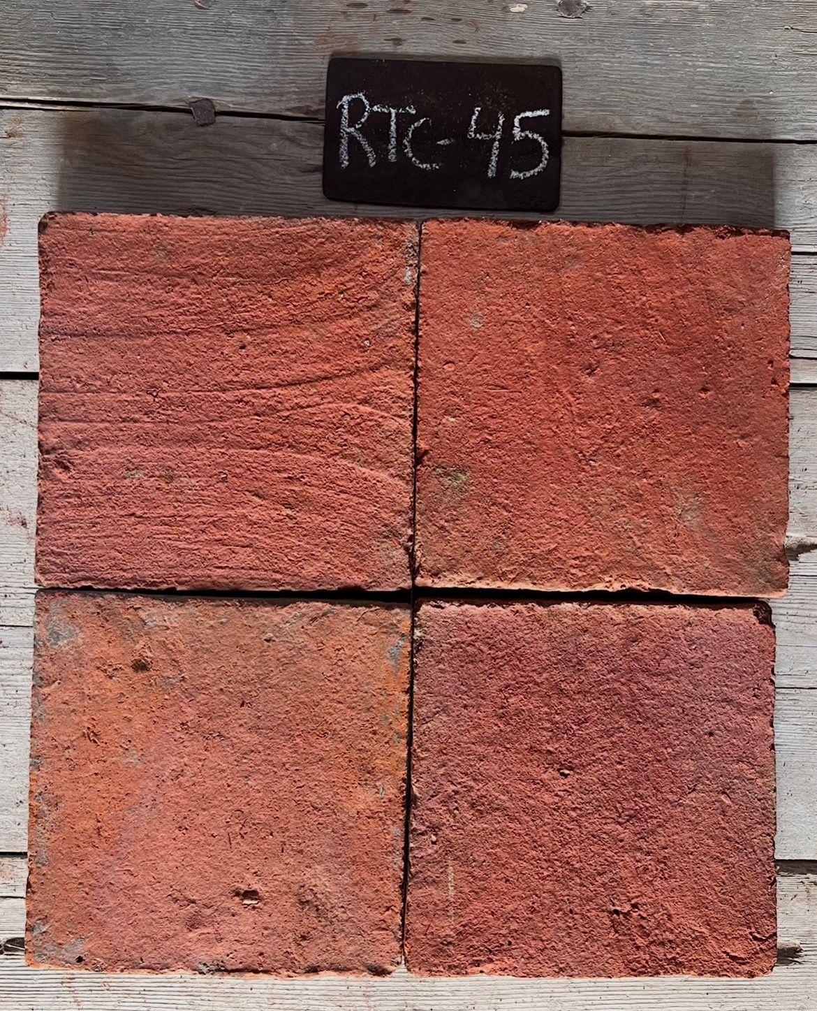 Cuatro piezas de barro cocido recuperado en terracota rojo con estrías horizontales, formato 20x20 cm