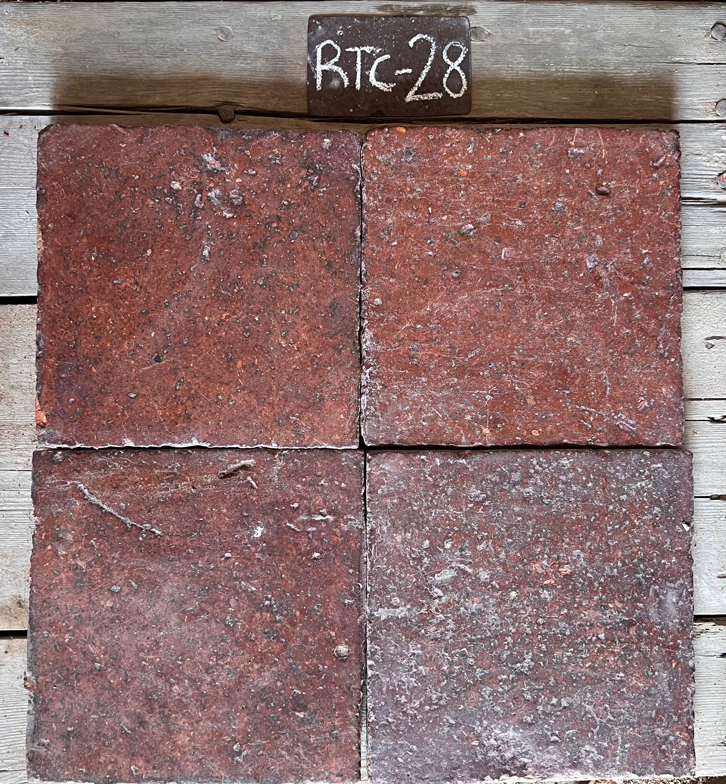 Cuatro piezas de barro cocido recuperado en terracota rojo oscuro, formato 25x25 cm