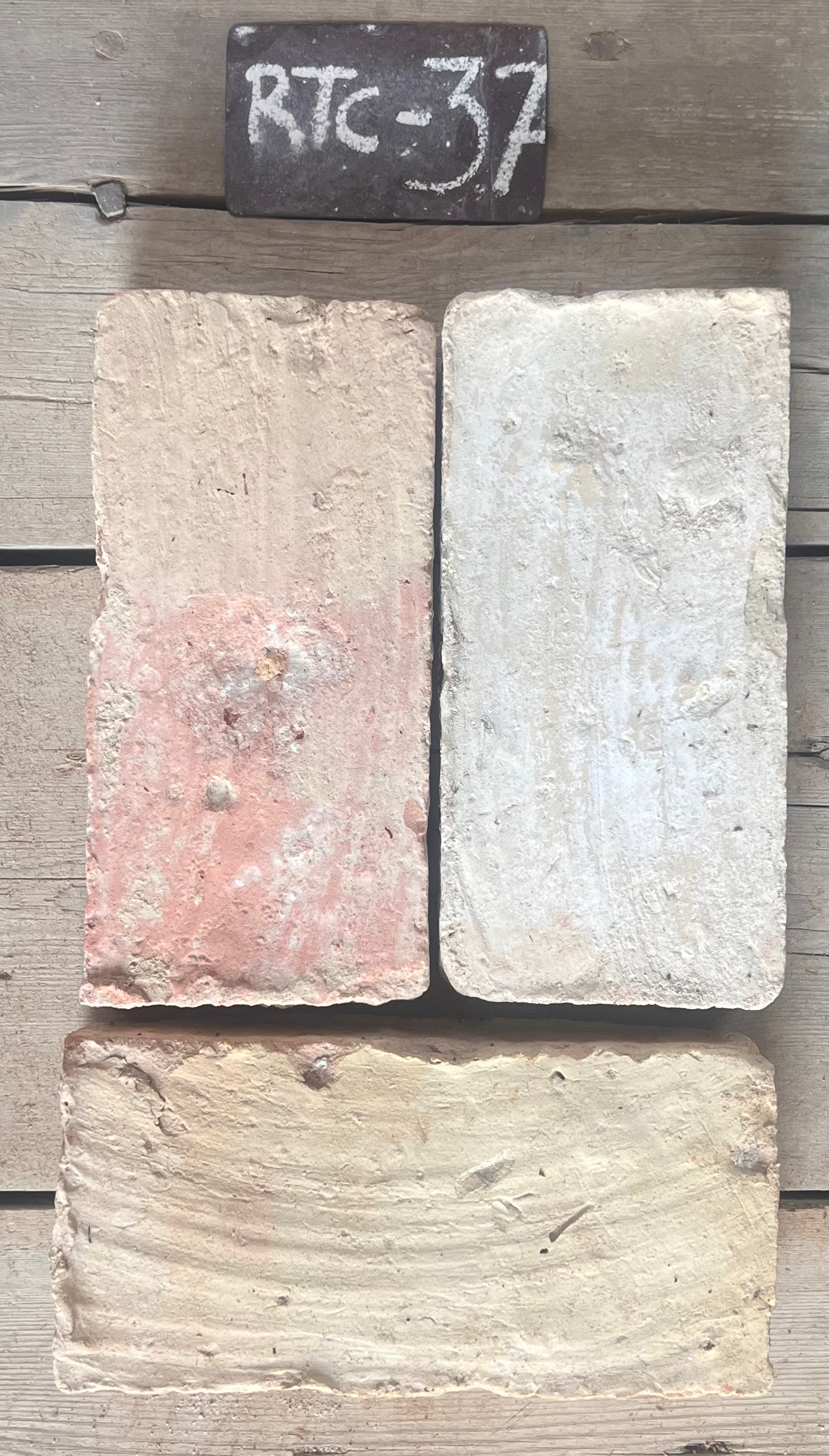 Dos piezas de barro cocido recuperado, una en terracota rosado y otra en blanco crema, formato 28x14 cm